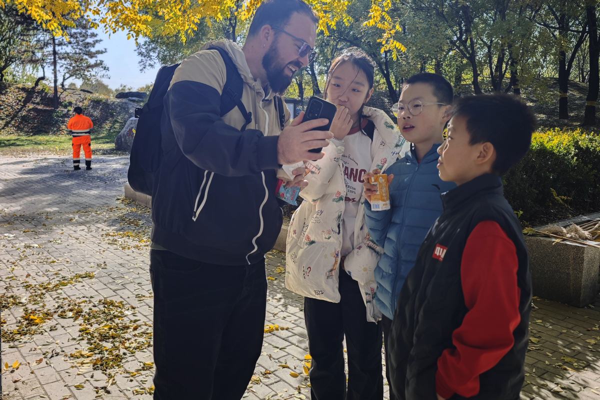 Teacher Reed showing something to a group of kids on an autumn walk
