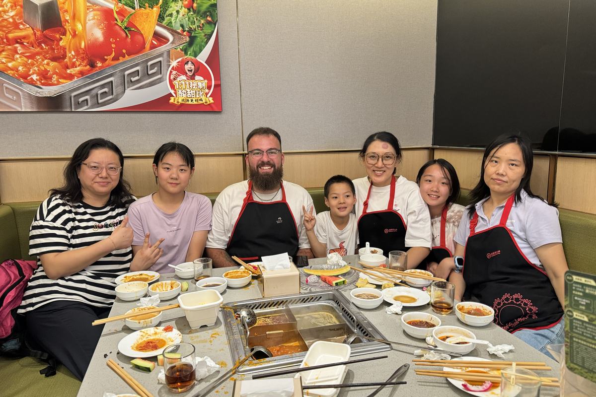 Teacher Reed sharing a hot pot dinner with a group of friends