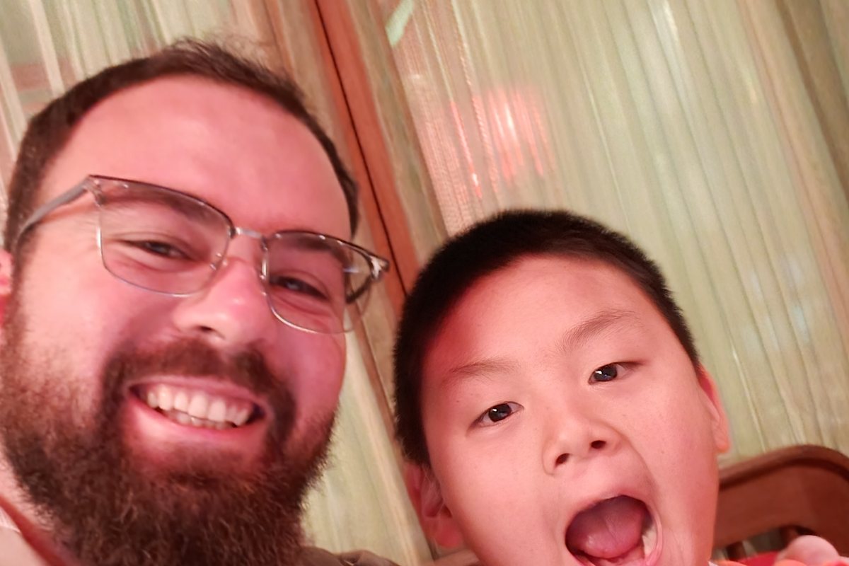 Teacher Reed taking a silly selfie with a boy who is shouting with excitement