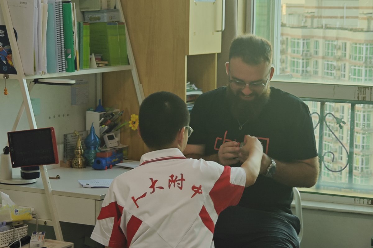 Teacher Reed working one-on-one with a young learner at a desk